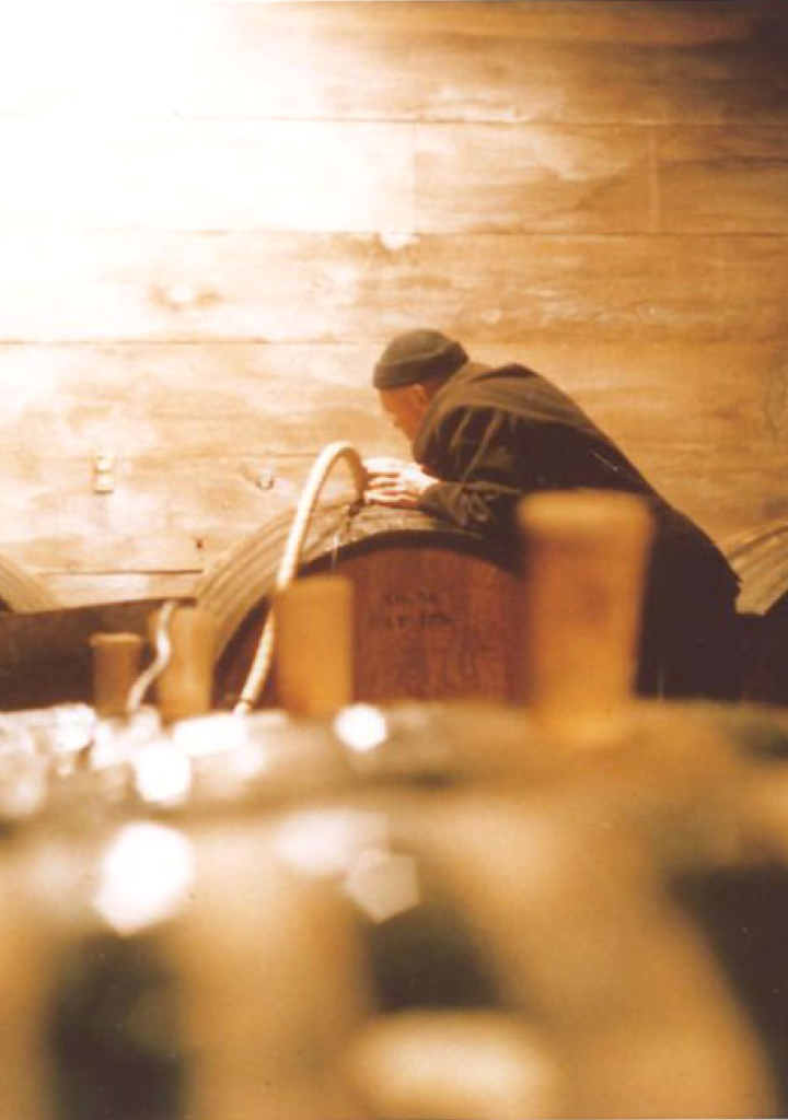 A man filling a wine barrel with grapes.