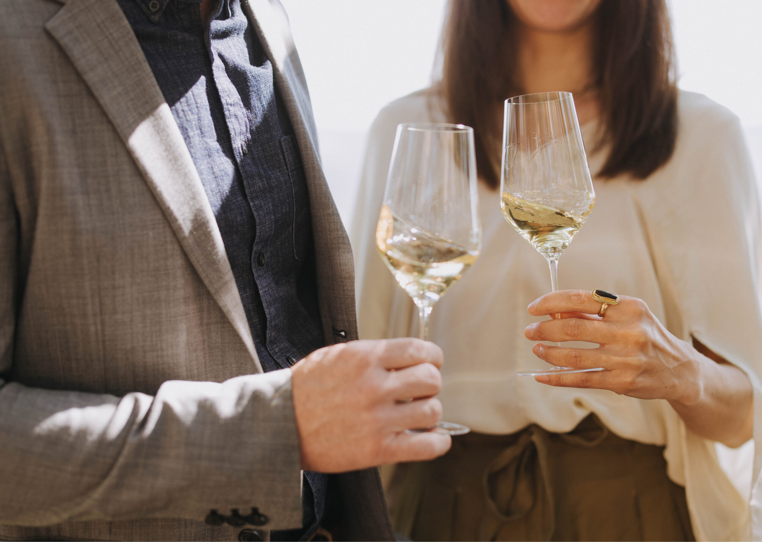 A couple outside each holding a glass of Stony Hill wine.