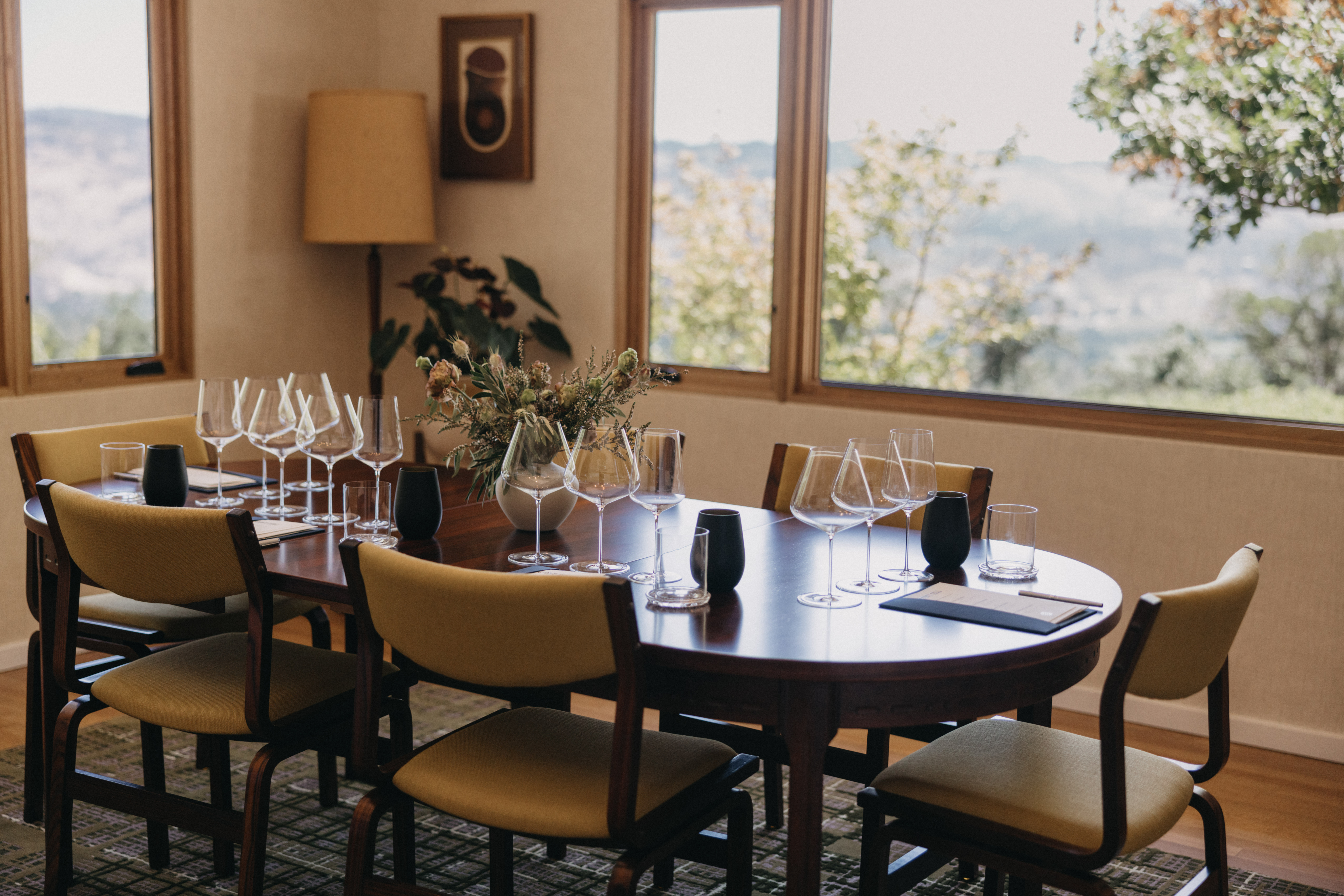 A table inside a room at the Stony Hill residences, with a setting ready for a tasting including wine glasses.