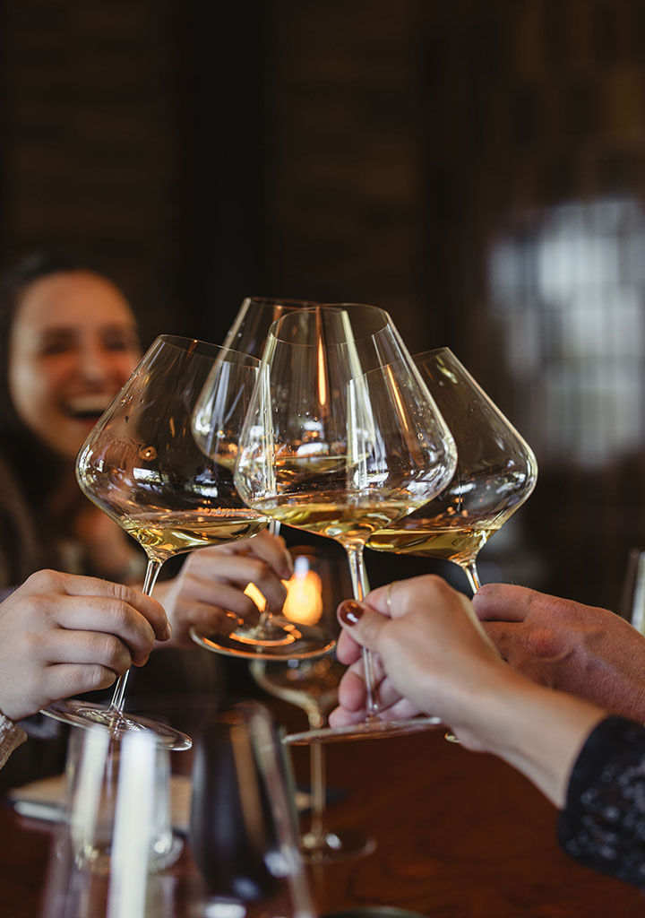 A group enjoying a tasting at Stony Hill and cheersing their glasses.